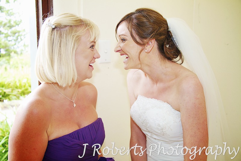 bride and bridesmaid share a joke and laugh - wedding photography sydney